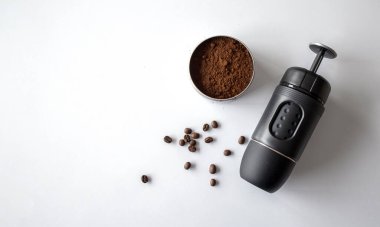 Espresso kahve makinesi, beyaz masa arkasında kahve fincanı ve fasulye. en üstteki görünüm