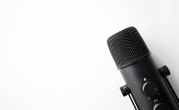 microphone on white table with soft-focus and over light in the background. space for text. 