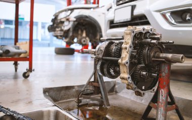 Servis merkezinde, arka planda hafif odaklı ve ışığın üzerinde olan araba motorunun yakın plan ayrıntıları