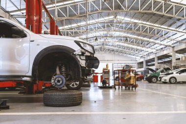 Otomobil tamirhanesinde hafif odaklı ve arka planında ışık olan bir araba.