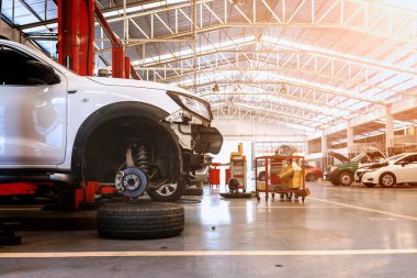 Otomobil tamirhanesinde hafif odaklı ve arka planında ışık olan bir araba.