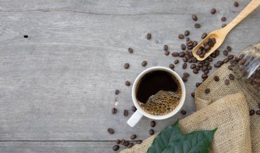 Tahta arka planda sıcak kahve ve fasulye. Üst Manzara. Metin için boşluk