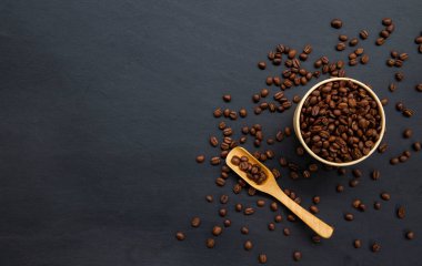 kahve çekirdekleri eski siyah tahta masa arkasında. Selamlama, kartlar, dergiler, kapaklar, posterler ve afişler vs. oluşturmak için model ve şablonlar. Metin için boşluk. Üst Manzara. düz yat