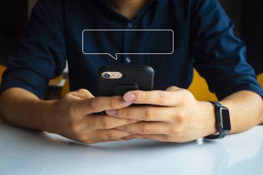 Erkekler el ele mesajlaşırken cep telefonlarını kullanırlar. Evde rahatlarlar. İleti için resim boş metin kutusu çerçevesini düzenle. yumuşak odaklı ve arka plandaki ışığın üzerinde