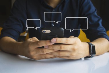 Erkekler el ele mesajlaşırken cep telefonlarını kullanırlar. Evde rahatlarlar. İleti için resim boş metin kutusu çerçevesini düzenle. yumuşak odaklı ve arka plandaki ışığın üzerinde
