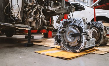 Servis merkezinde, arka planda hafif odaklı ve ışığın üzerinde olan araba motorunun yakın plan ayrıntıları