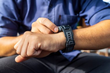 Tebligat açmak için ekranda dijital akıllı saat takan işadamı, hafif odaklı ve arka planda ışık üzerinden mesaj ve etkinlik takip cihazını okuyun.