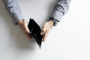 Yakın plan boş cüzdan (para yok) yumuşak odaklı bir adamın ellerinde ve arka planda ışık üzerinde