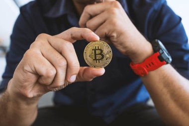 Altın Bitcoin, ofisteki bir işadamının elinde, yumuşak odaklı ve özgeçmişli. şifreleme para birimi kavramı