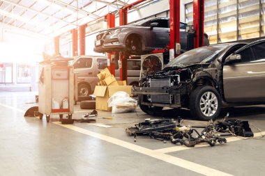 Otomobil tamirhanesinde hafif odaklı ve arka planında ışık olan bir araba.