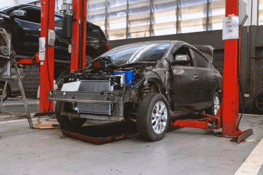 Otomobil tamirhanesinde hafif odaklı ve arka planında ışık olan bir araba.