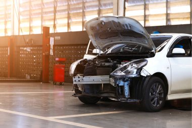 Otomobil tamirhanesinde hafif odaklı ve arka planında ışık olan bir araba.