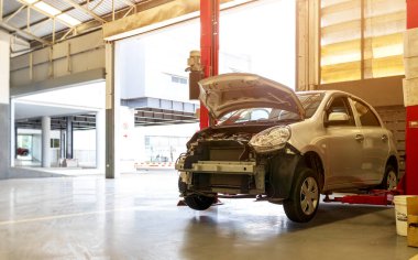 Otomobil tamirhanesinde hafif odaklı ve arka planında ışık olan bir araba.