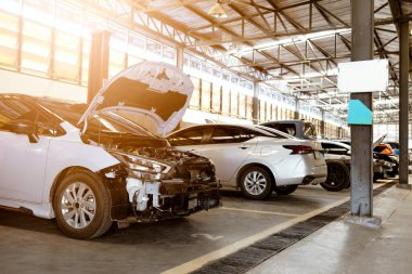 Parlak endüstriyel garajda bakım altında olan birkaç arabalı profesyonel oto tamir atölyesi.