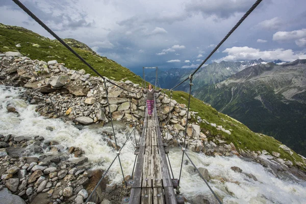 Jong meisje toerist die zich op de houten brug bij de berg — Stockfoto