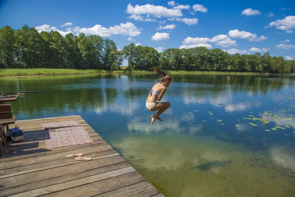 Girl jumping into lake — Stock Photo, Image
