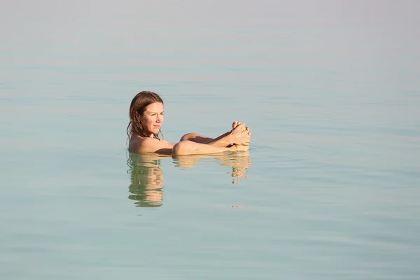 Schönes Mädchen, das im toten Meer schwimmt — Stockfoto