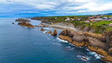 Liencres, Cantabria, İspanya yakınlarındaki Costa Quebrada uçurumlarının hava manzarası dramatik kaya oluşumları ve turkuaz kıyı suları.
