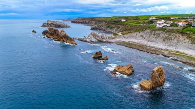 Liencres, Cantabria, İspanya yakınlarındaki Costa Quebrada uçurumlarının hava manzarası dramatik kaya oluşumları ve turkuaz kıyı suları.