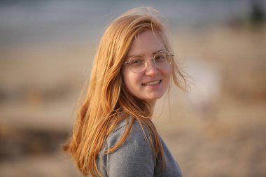 Kızıl Saçlı ve Gözlüklü Mutlu Genç Kadın Kumsalda Gülümsüyor