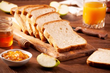 Kahvaltı için reçelli ekmek dilimleri ve meyve suyu.