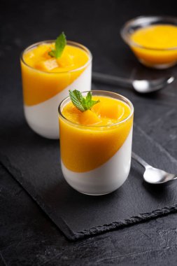 Bir bardak ev yapımı panna cotta ve mango sosu.