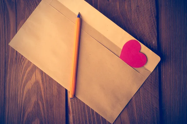 Karton zarf eklenen sembolik kalbinde. Valentin — Stok fotoğraf