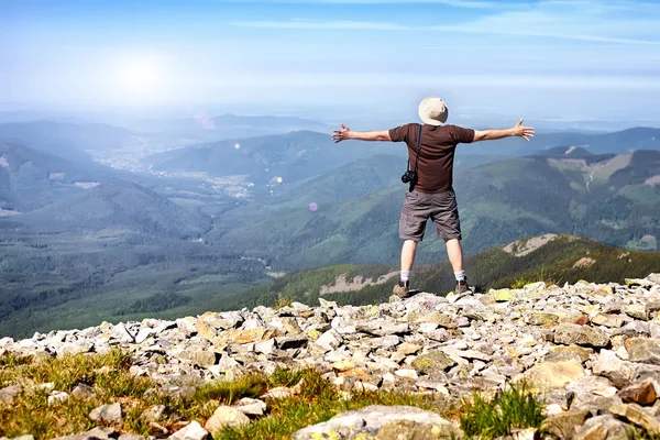 Турист с камерой стоит в горах и наслаждается соревнованиями — стоковое фото
