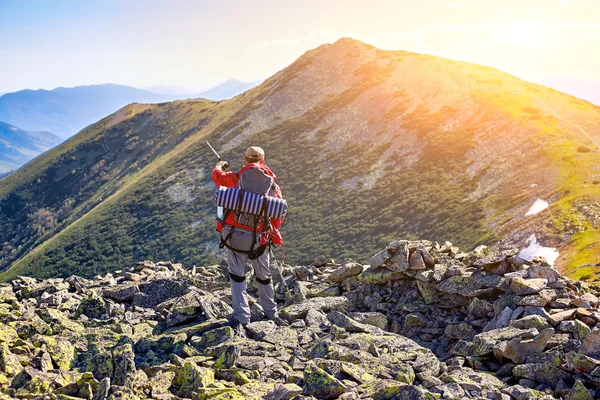 Caminhante com mochila em pé nas montanhas e desfrutar do v — Fotografia de Stock