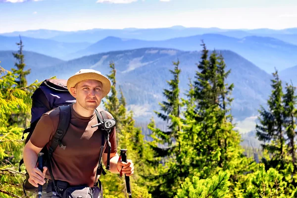 Турист с рюкзаком на вершине горы — стоковое фото
