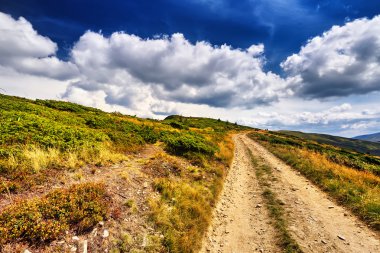 Alan yolu mavi gökyüzünün altında dağlarda. Dramatik sahne.