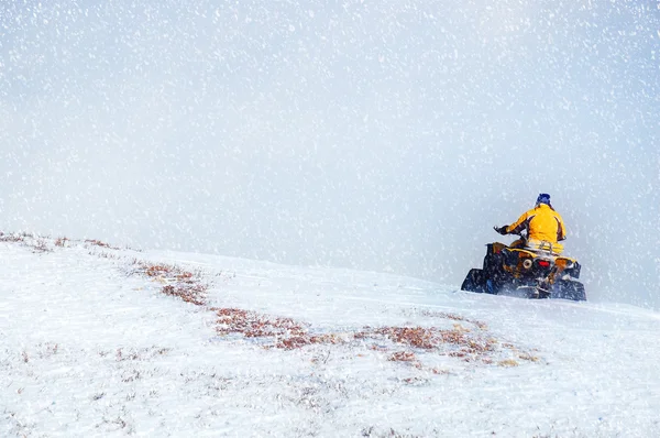 Hombre conduciendo moto de nieve en montaña de invierno. Hermosa nevada — Foto de Stock