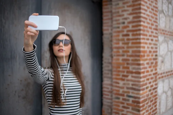 Metal duvar karşı selfie alarak odaklanmamış kız 
