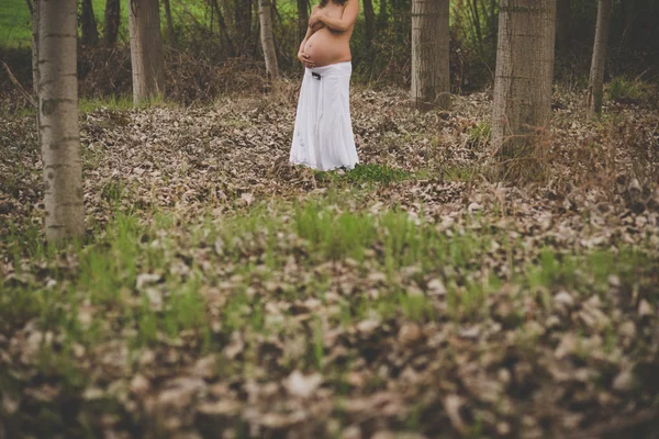 Topless pregnant woman embracing her belly — Stock Photo, Image