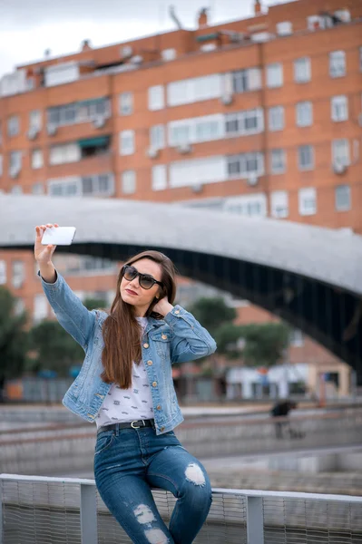 Ragazza bruna facendo selfie sul ponte Immagine Stock