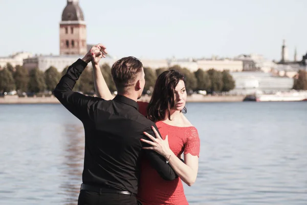 Young couple dancing together against the old city background. Travel and lifestyle concepts. Special tone effect.