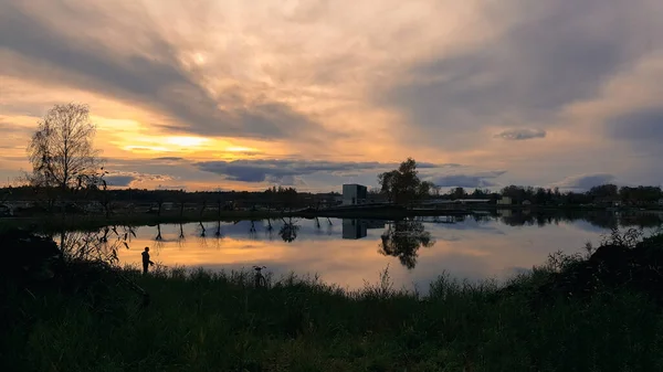 劇的な雲と湖の上に夕日の空 湖の近くの漁師の水面やシルエットに映る雲 — ストック写真