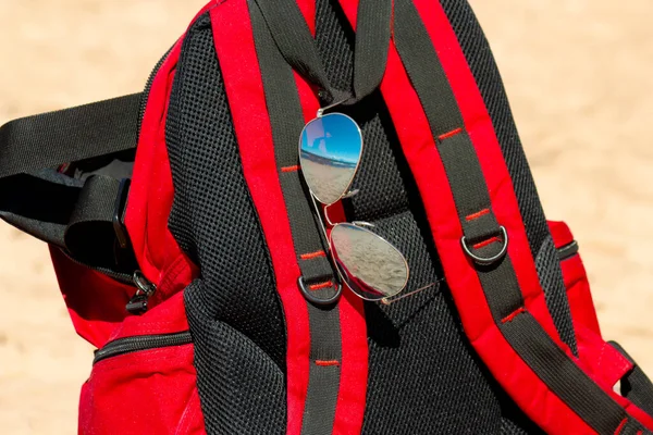 Červený Batoh Sluneční Brýle Pláži Detailní Sportovní Rekreační Koncept — Stock fotografie