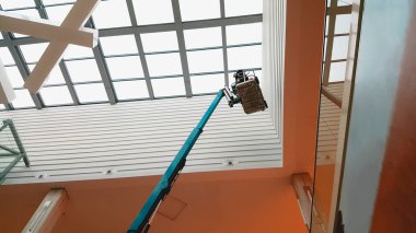 Alışveriş merkezinin içinde asansör kovasında çalışan bir işçi.