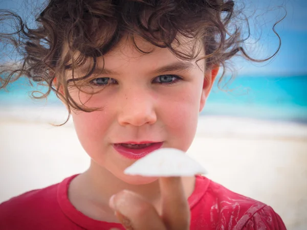 Meisje bedrijf shell op strand — Stockfoto