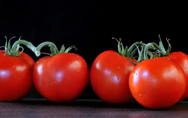 Siyah arkaplanda domatesler. — Stok fotoğraf