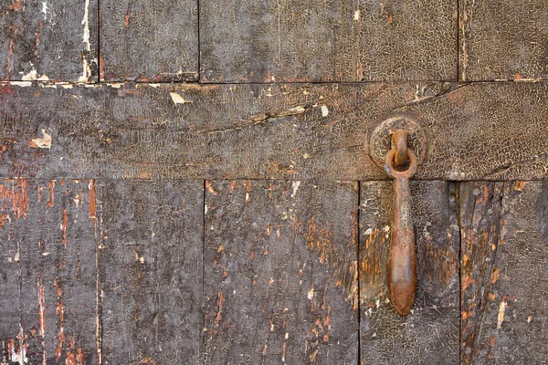 Крупним планом бурхливі дерев'яні двері з іржавим дзвіночком — стокове фото