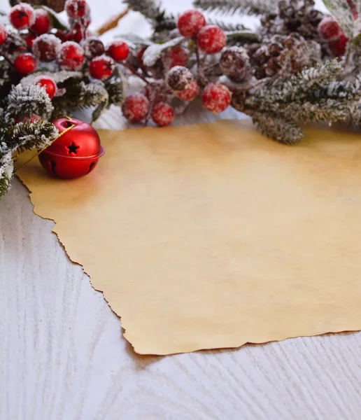 Verschneiter Tannenzweig mit Beeren über Packpapier — Stockfoto