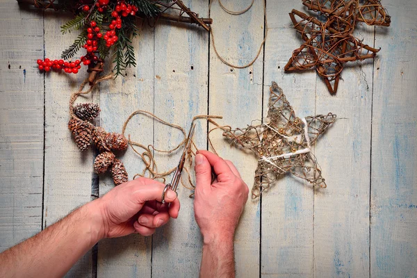 Las manos del hombre hacen un trabajo elegante con decoraciones de árboles de Navidad —  Fotos de Stock