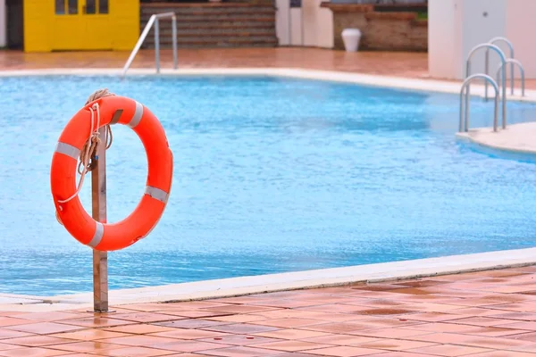 Boa di salvataggio arancione appesa vicino alla piscina — Foto Stock