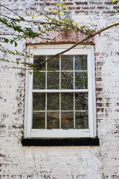 Oude venster op witgekalkte bakstenen huis — Stockfoto