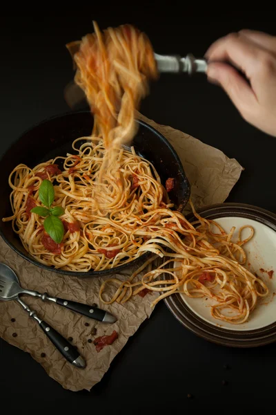 Linguine con albahaca y salsa roja en sartén de hierro fundido que se sirve —  Fotos de Stock