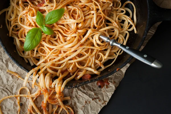 Linguine con salsa roja y albahaca fresca en una sartén de hierro fundido —  Fotos de Stock