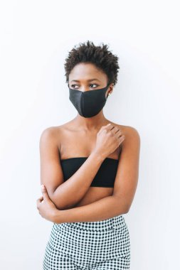 Siyah bluzlu ve yüz maskeli güzel Afro-Amerikan kadın beyaz arka planda izole, koronavirüs konseptini durdurun