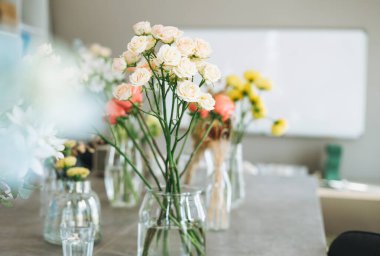 Masadaki cam vazoda duran şeftali gülleri. Çiçekçi işyeri